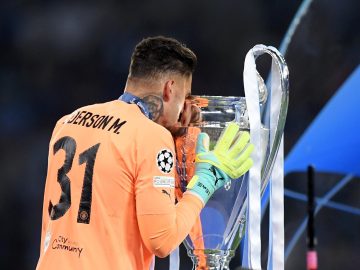 Ederson beijando a taça da Champions depois de ser campeão pelo City | Foto: Michael Regan | UEFA/UEFA - Getty Images